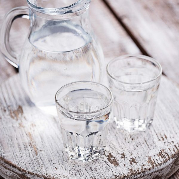 Glasses and jug of cold water. Selective focus